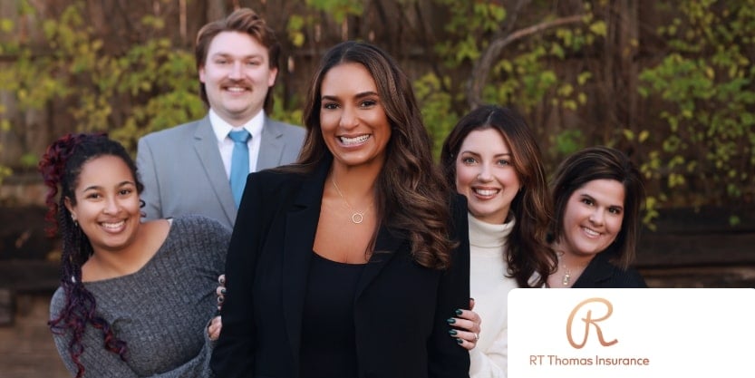 The staff of RT Thomas Insurance smiles at a camera. 