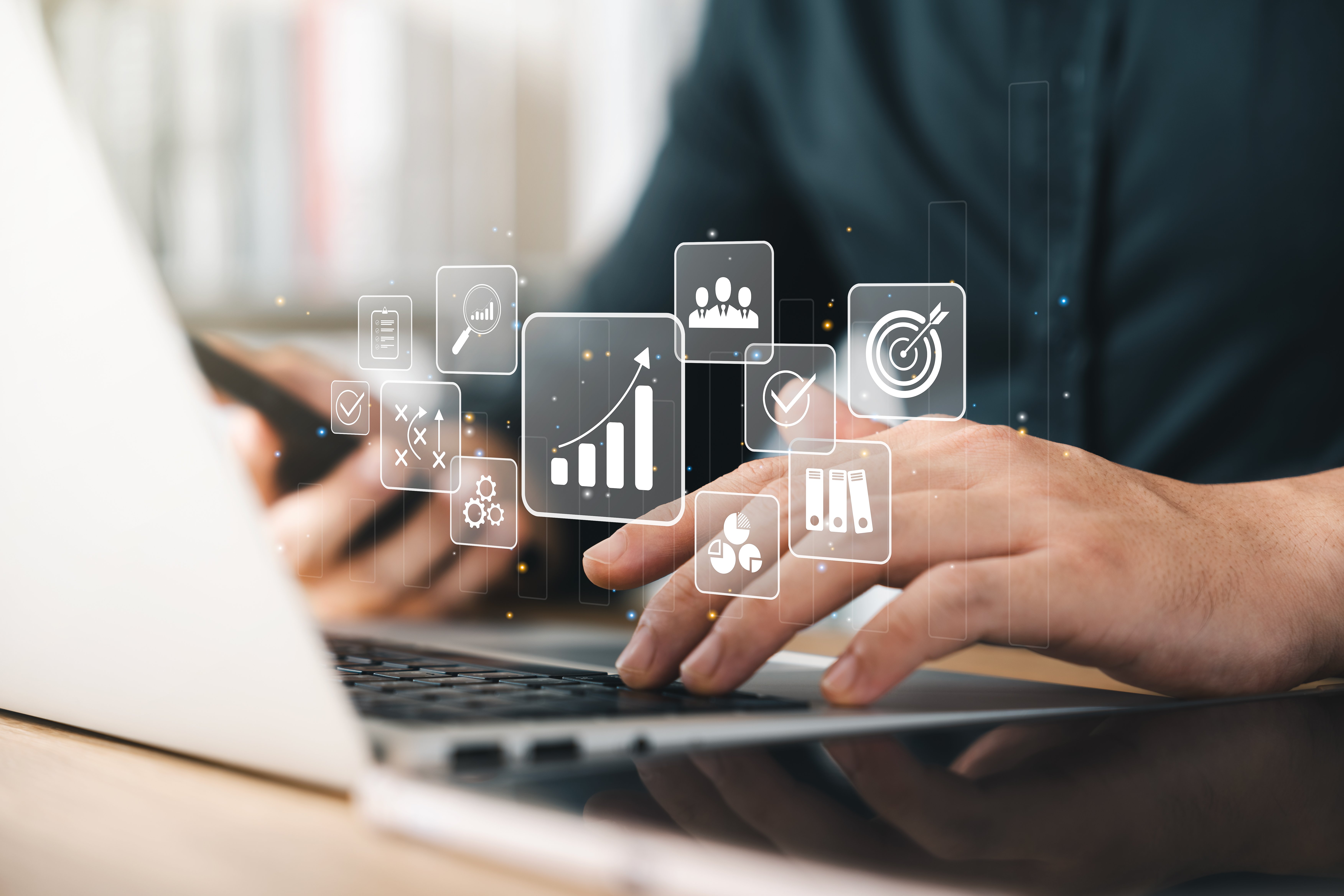 A man types on a laptop. Iconography is overlaid over the image to represent a computer program.