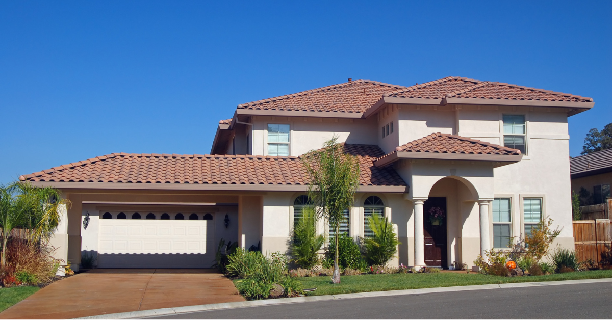 A beige Mediterraneans style house with clay roof tiles.